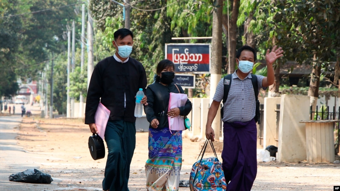 Jurnalis Associated Press Thein Zaw (kanan) melambaikan tangannya ketika berjalan bersama pengacaranya Tin Zar Oo (tengah) setelah ia dibebaskan dari penjara Insein di Yangon, pada 24 Maret 2021. Thein ditangkap saat meliput demo menentang kudeta militer di Myanmar. (Foto: AP)