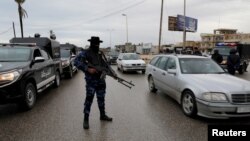 Un agent de sécurité tient une arme lors d'un déploiement dans le quartier de Tajura, à l'est de Tripoli, en Libye, le 30 décembre 2019.