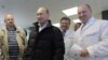 Russia -- businessman Yevgeny Prigozhin, right, smiles as he shows Russian President Vladimir Putin, center, around his factory which produces school means