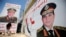 Salah Abdel Moneim, 40, a supporter of Egypt's army, walks in front of his shop, plastered with huge posters of General Abdel Fattah al-Sisi, Cairo, Aug. 7, 2013.
