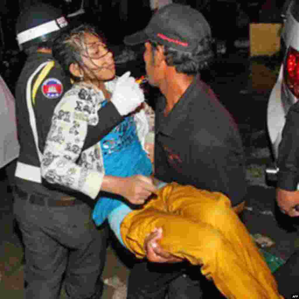 An injured Cambodian is carried by police officers and another visitor after a deadly stampede in Phnom Penh, Cambodia, Monday, Nov. 22, 2010. Thousands of Cambodians celebrating a water festival by the river in the Cambodian capital stampeded Monday nig