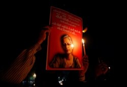 FILE - People hold placards and candles, Sept. 6, 2017, during a vigil for Gauri Lankesh, a senior Indian journalist shot dead outside her home by unidentified assailants in southern city of Bengaluru, in Ahmedabad, India.