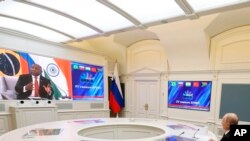 Russian President Vladimir Putin listens leaders from the BRICS group of emerging economies at the start of a three-day summit in Johannesburg, South Africa via videoconference from Moscow, Aug. 22, 2023.