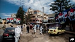 Pulvérisation de désinfectant pour empêcher la propagation du coronavirus à Qamishli, en Syrie le 24 mars 2020.