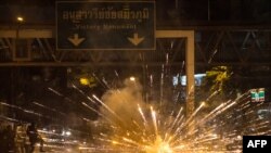 Fireworks, thrown by protesters, explode in front of a line of police during a demonstration against Thai Prime Minister Prayut Chan-O-Cha and his government&#39;s handling of the Covid-19 crisis in Bangkok.