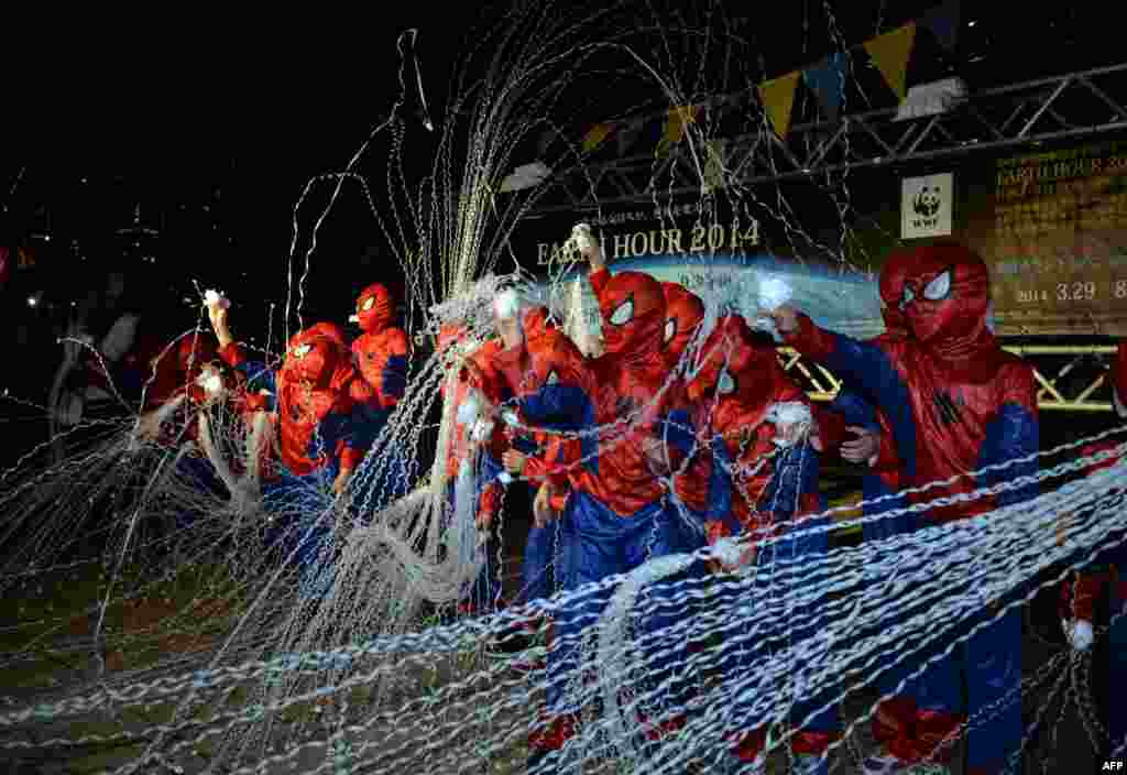 Children dressed as spiderman throw &quot;spider thread&quot; for the count down of the Earth Hour environmental campaign event in suburban Tokyo, Japan.