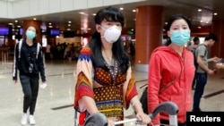 ကိုရိုနာဗိုင်းရပ်စ် ကာကွယ်နိုင်ရေး နှာခေါင်းစည်းတပ်ထားသည့် ရန်ကုန်အပြည်ပြည်လေဆိပ်မှ ထွက်ခွာမည့် ခရီးသည်များ။ (ဇန်နဝါရီ ၃၁၊ ၂၀၂၀)