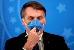 El presidente de Brasil, Jair Bolsonaro, ajusta su mascarilla protectora en un comunicado de prensa durante el brote de la enfermedad por coronavirus (COVID-19) en Brasilia el siete de julio del 2020.