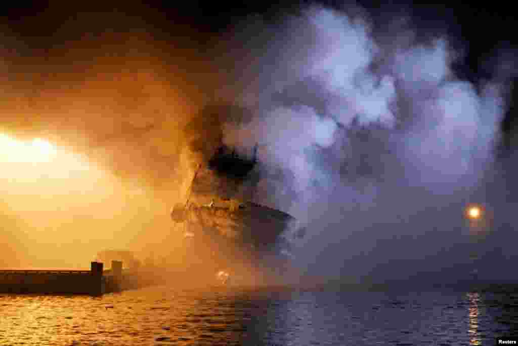 The Russian fishing trawler Bukhta Naezdnik burns in the harbor of Tromso, Norway.