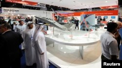 Visitors walk past a stand for Italian defence group Finmeccanica during the International Defense Exhibition and Conference (IDEX) at the Abu Dhabi National Exhibition Centre, February 19, 2013. 