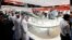 Visitors walk past a stand for Italian defence group Finmeccanica during the International Defense Exhibition and Conference (IDEX) at the Abu Dhabi National Exhibition Centre, February 19, 2013. 