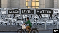 Seorang pengendara sepeda melewati mural "Black Lives Matter" di Union Square pada 12 Juni 2020 di New York City. Demonstrasi diadakan di seluruh AS setelah kematian George Floyd pada 25 Mei 2020. (Foto: AFP)