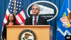 El Fiscal General Merrick Garland con la Fiscal General Auxiliar Kristen Clarke de la División de Derechos Civiles, habla durante una conferencia de prensa en el Departamento de Justicia en Washington, el jueves 4 de agosto de 2022.