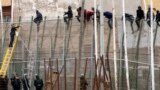 افسر گارد ملی اسپانيا (چپ) ساندويچی را به&zwnj;طرف پناه&zwnj;جويان آفريقايی که بر بالای حصار نشسته&zwnj;اند پرتاب می&zwnj;کند. اين پناه&zwnj;جويان مترصد عبور از مرز بين مراکش و ناحيه آفريقايی تحت محاصره اسپانيا موسوم به مليلا و ورود به خاک اسپانيا هستند.