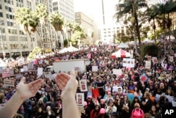 Protesters listen to a speaker as they gather for the Women's March against President Donald Trump, Jan. 21, 2017, in Los Angeles.