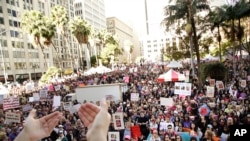 Protesters listen to a speaker as they gather for the Women's March against President Donald Trump, Jan. 21, 2017, in Los Angeles.