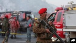 An Afghan soldier stands guard by a damaged bus at the site of a suicide attack by the Taliban in Kabul, Afghanistan, December 2014. Officials warn of similar violence this week and have alerted U.S. citizens in Afghanistan. (AP Photo/Rahmat Gul)