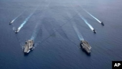美国海军的尼米兹号和里根号航空母舰组成的双航母战斗群7月6日在南中国海航行。（美国海军提供）