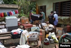 Volunteers collect household items in the lawns of a residential house before cleaning the house following floods in Kuttanad in Alappuzha district in the southern state of Kerala, India, Aug. 28, 2018.