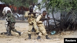Somali government soldiers open fire during an ambush by al-Shabaab rebels on the outskirts of Elasha town, May 29, 2012.