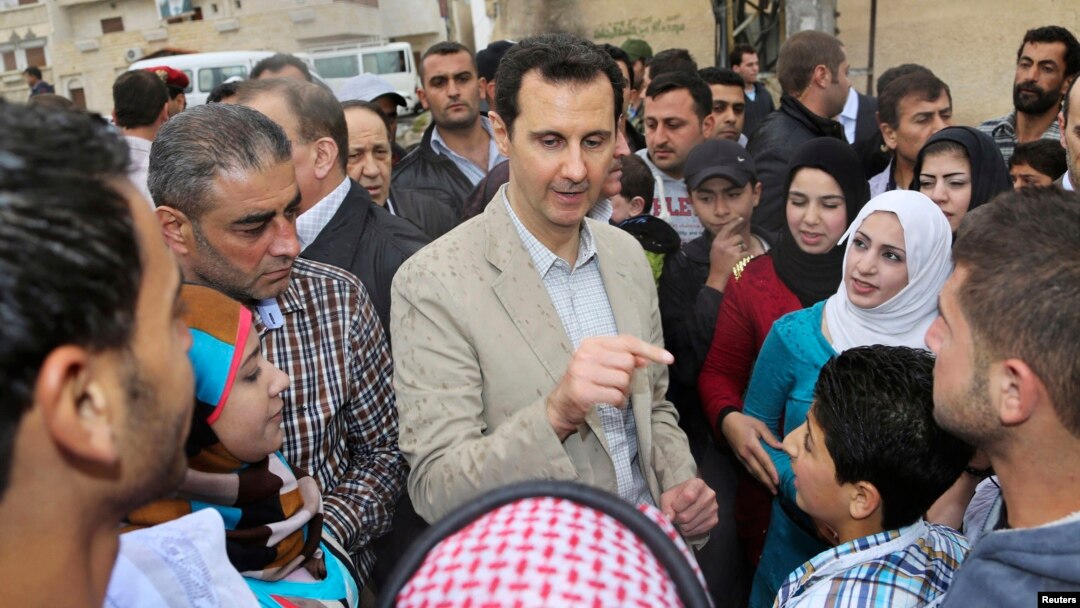 Presiden Suriah Bashar al-Assad (tengah) berbincang dengan warga saat berkunjung ke desa Ein al-Tinah, timur laut Damaskus (20/4).