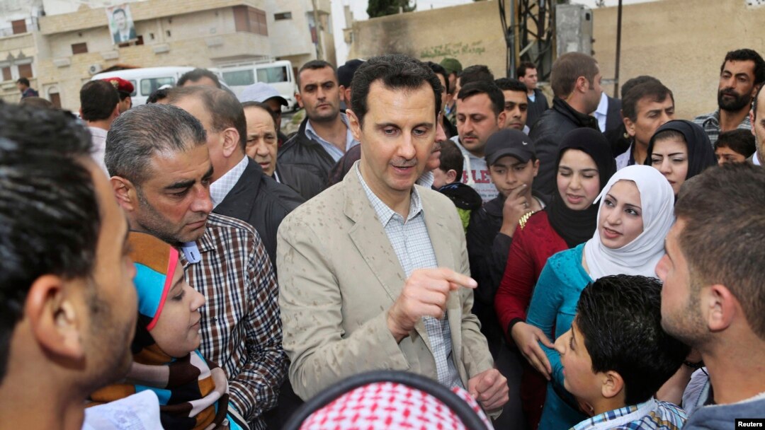 Syrian President Bashar al-Assad chats with people during his visit to Ein al-Tinah village, northeast of Damascus, April 20, 2014.