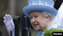 Britain's Queen Elizabeth waves as she arrives for a service of thanksgiving at Saint Macartin's Cathedral in Enniskillen, Northern Ireland, June 26, 2012. 