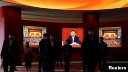 2022年10月12日参观者走过习近平和历届共产党代表大会的照片