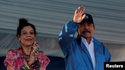 El presidente de Nicaragua, Daniel Ortega, y la vicepresidenta, Rosario Murillo, saludan en un evento para conmemorar el 40 aniversario de la toma del palacio nacional por los Sandinistas en 1978. 22 de Agosto de 2020.