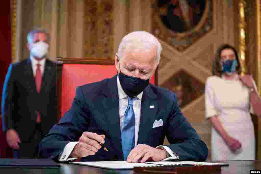 U.S. President Joe Biden signs three documents including an Inauguration declaration, cabinet nominations and sub-cabinet nominations in the Presidents Room at the U.S. Capitol after the 59th Presidential Inauguration in Washington, U.S., Jan. 20, 2021. 