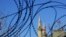 FILE - Turkish and Turkish Cypriot breakaway flags flying on the minarets of the Selimiye mosque or Agia Sofia, are seen through the barbed wires of the U.N. buffer zone that divides the Greek and Turkish Cypriots controlled areas, in the divided capital of Nicosia, Cyprus, Jan. 12, 2017.