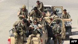 FILE - Afghan Special Forces arrive at the airport as they launch a counteroffensive to retake the city from Taliban insurgents, in Kunduz, Sept. 29, 2015. 