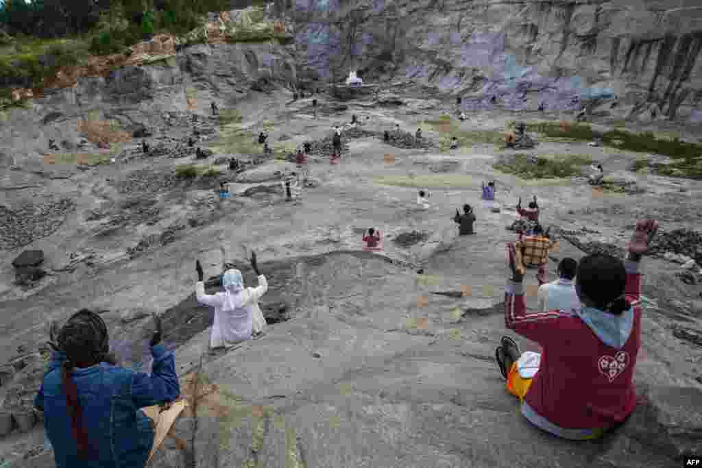 Father Pedro (back), founder of the Akamasoa association, conducts the traditional Mass celebrating Easter in a granite quarry in Antananarivo, Madagascar, while respecting the rules of social distancing to curb the spread of the coronavirus.