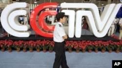 FILE - A security guard walks past the logo for China Central Television (now China Global Television Network) in Beijing Thursday, Aug. 24, 2006.