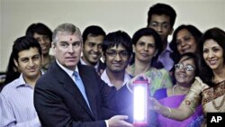 Britain's Prince Andrew, second left, holds a solar lamp as students and teachers look on during his visit to H.R. College of Commerce and Economics in Mumbai, India (file photo – 09 Mar. 2010)