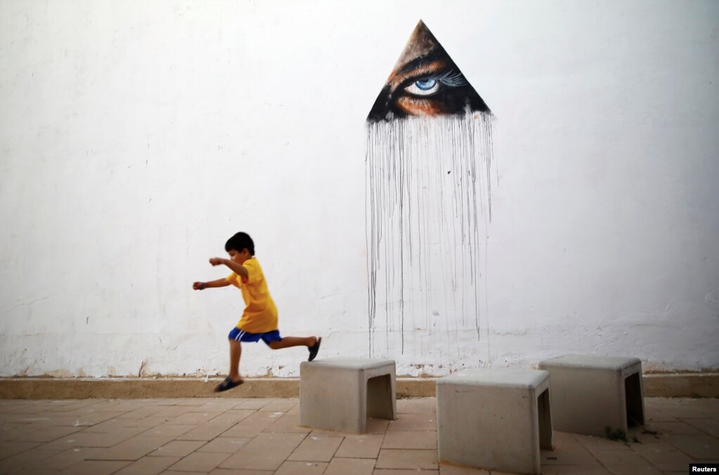 이스라엘 남부도시 아라드에서 진행된 '파우와우 이스라엘(POW! WOW! Israel)' 문화예술 축제 현장에서 하와이 출신 작가 카메아 하다의 벽화 앞으로 어린이가 지나가고 있다.