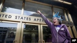 FILE - In this June 19, 2018, file photo, protester Ann Marie Stenberg yells outside the Immigration and Customs Enforcement office in San Francisco. A U.S. judge in California struck down an immigration law, Oct. 5, 2018, that the Trump administration has used to go after cities and states that limit cooperation with immigration officials. 