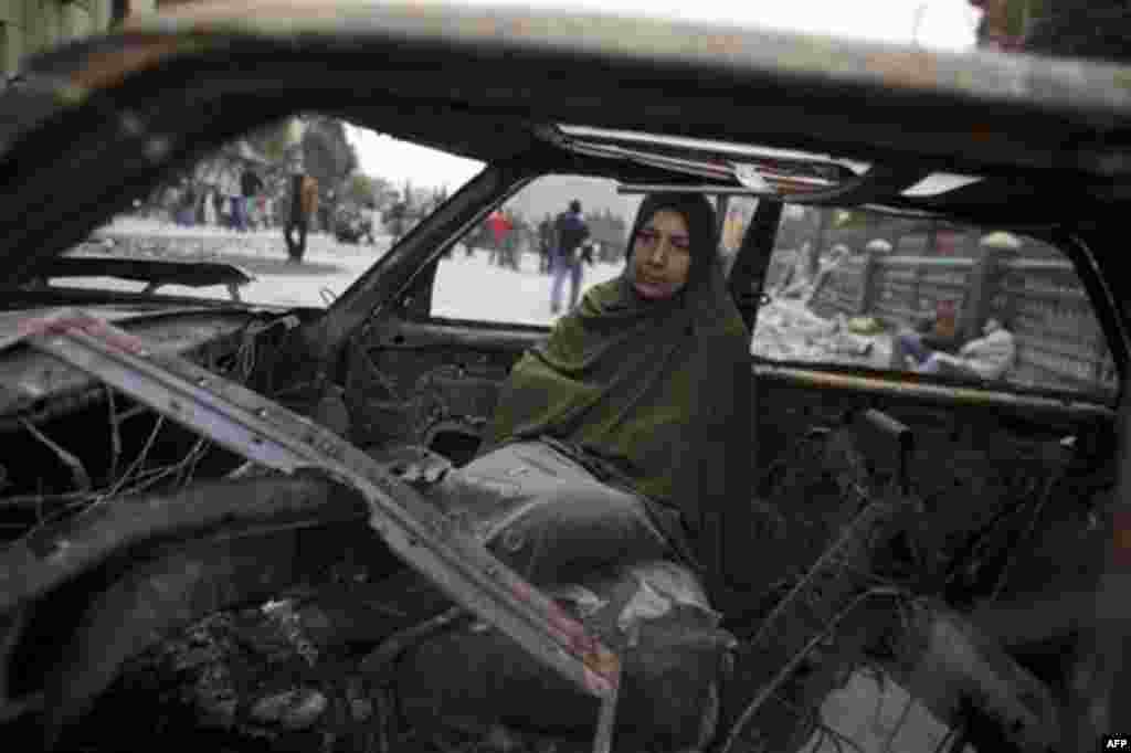 An anti-government protester rests in a burnt out car during clashes near Tahrir, or Liberation square in Cairo, Egypt, Thursday, Feb. 3, 2011. New clashes are heating up and shots are being fired in the air around Cairo's central Tahrir Square as anti-go