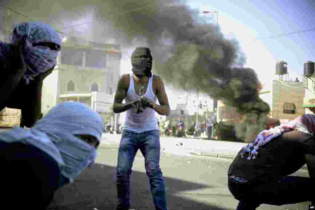 A Palestinian holds a Molotov cocktail during clashes with Israeli border police in Jerusalem, July 2, 2014. 