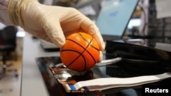 Dr. Benjamin Tee, Assistant Professor of Materials Science and Engineering at the National University of Singapore (NUS), demonstrates how his device can detect the texture of a soft stress ball at a lab in NUS, Singapore July 27, 2020. (REUTERS/Joseph Campbell)