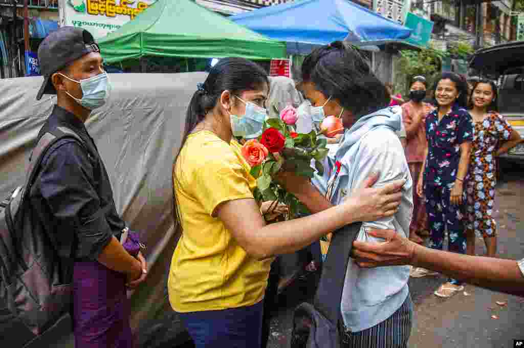 An anti-coup student protester is welcomed home with flowers by the residents of her neighborhood after being released from jail, in Yangon, Myanmar.