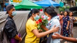 An anti-coup student protester is welcomed home with flowers by the residents of her neighborhood after being released from jail, in Yangon, Myanmar.