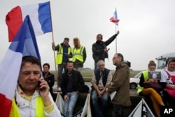 Demonstrators hold French flags as truckers block the highway near Calais, northern France, Sept. 5, 2016.