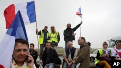 Demonstrators hold French flags as truckers block the highway near Calais, northern France, Sept. 5, 2016. 