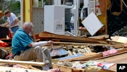 Un anciano descansa mientras busca recuerdos en su destruida casa en Tupelo, Mississippi.