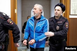 Partner in the Baring Vostok private equity group Vagan Abgaryan, who was detained on suspicion of fraud, is escorted inside a court building in Moscow, Russia, Feb. 15, 2019.