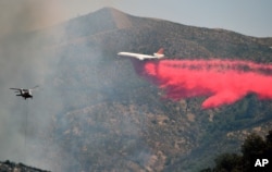 An air tanker drops fire retardant at a containment line northeast of Lower Lake, Calif.