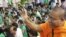 A Cambodian Buddhist monk sprinkles holly water to villagers who set a prayer rally to save rain forests in front of Royal Palace in Phnom Penh, Cambodia, Thursday, Aug. 18, 2011. Hundreds of villagers prayed at the spirit's shrine, demanding the governme