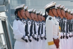FILE - Chinese People's Liberation Army Navy troops stand in formation on the deck of a type 054A guided missile frigate "Wuhu" as it docks in Manila, Philippines, Jan. 17, 2019.