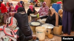 (FILE) Sudanese women from community kitchens run by local volunteers prepare meals for people who are affected by conflict and extreme hunger and are out of reach of international aid efforts, in Omdurman, Sudan, May 13, 2024. 